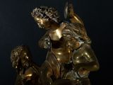 bronze statue of a woman holding a child on a black background