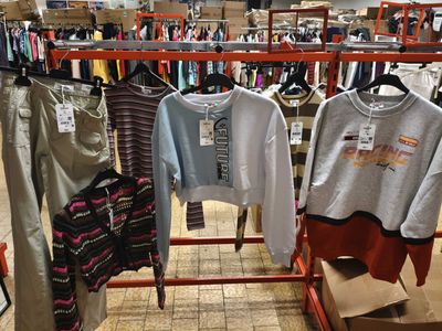 de nombreuses chemises suspendues à un portant dans un magasin