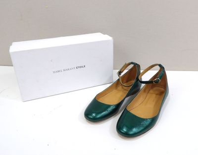 the green shoes are next to a white box on the table