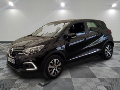 une voiture noire est garée sur le sol en damier d'un garage