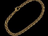 un bracelet en or avec un motif tressé sur fond noir