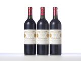 three bottles of red wine sitting on top of a white table