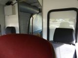 a view of the inside of a bus with red seats