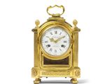 une horloge dorée avec un cadran blanc sur fond blanc