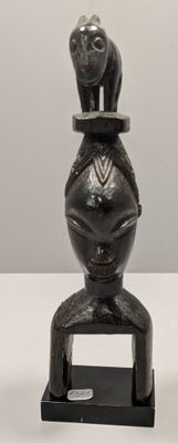 a statue of a woman sitting on top of a vase