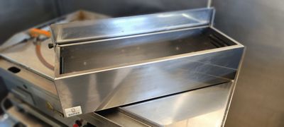 une boîte en métal avec un couvercle, posée sur une cuisinière