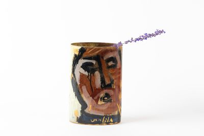 un vase contenant une fleur, posé sur une surface blanche