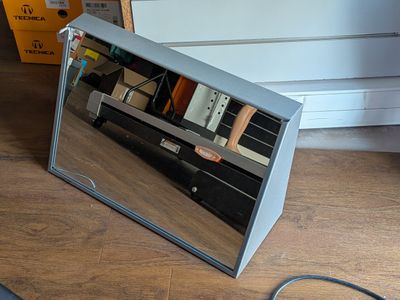 a mirror that is sitting on the floor next to a laptop