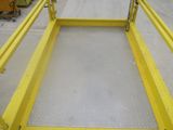a yellow trailer with a ramp attached to it in a warehouse