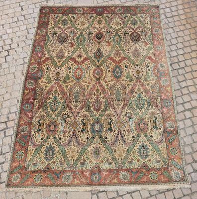 un tapis persan ancien posé sur un sol pavé