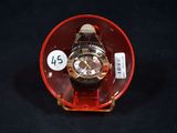 a watch sitting inside of a red case on a black surface