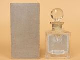 l'image d'un flacon de parfum posé à côté d'une boîte