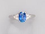 une bague à trois pierres, composée d'un saphir bleu et de diamants