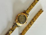 an image of a gold watch and a gold bracelet on a white surface