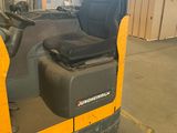 a yellow forklift truck with a black seat in a warehouse