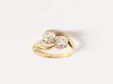 a close up of a gold ring with two diamonds on it