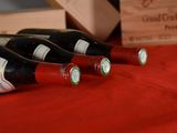 several bottles of wine are lined up on a red table cloth