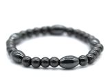 a close up of a black beaded bracelet on a white background