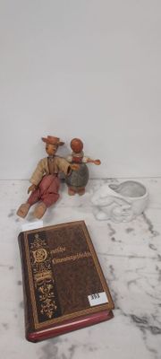 des figurines représentant deux hommes assis sur un sol en marbre, à côté d'un livre