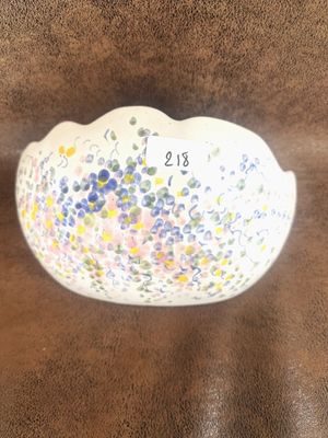 un bol blanc orné de fleurs, posé sur une surface marron
