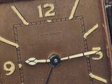 a clock that is sitting on a table next to a brick wall