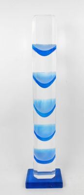 un grand vase en verre avec un socle bleu sur fond blanc