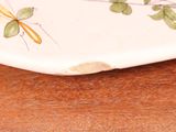 a plate with a bird on it sitting on a table