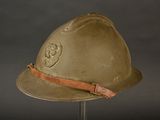an old helmet on a stand with a leather strap