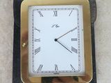 a small square clock with roman numerals on it