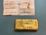a close up of a gold bar and a receipt on a table