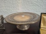 a silver cake stand with a silver plate on it