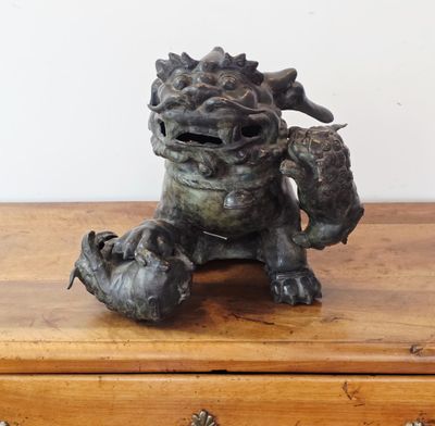 une statue représentant un dragon assis sur une table en bois