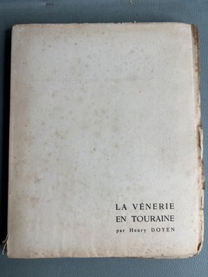 an old book sitting on top of a blue table next to a cup of coffee