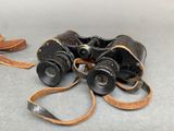 a pair of binoculars sitting on the ground next to a pair of shoes