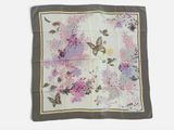 un gros plan sur un foulard carré orné de fleurs et de papillons