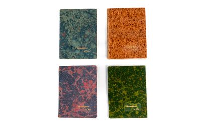quatre livres sont alignés sur une surface blanche