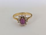 une bague en or sertie d'une pierre rose entourée de petits diamants blancs