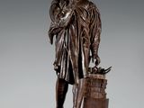 statue en bronze représentant un homme avec un oiseau sur l'épaule