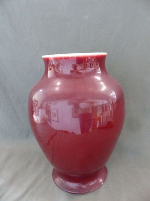 un vase rouge posé sur une table