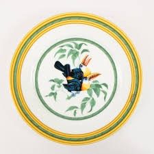 une assiette sur laquelle est représenté un oiseau, sur un fond blanc