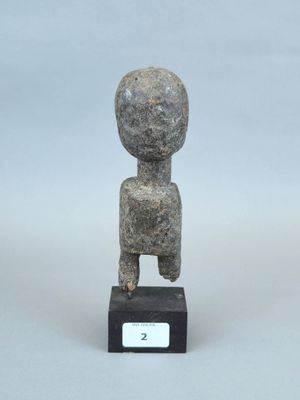statue représentant une personne assise sur un socle noir