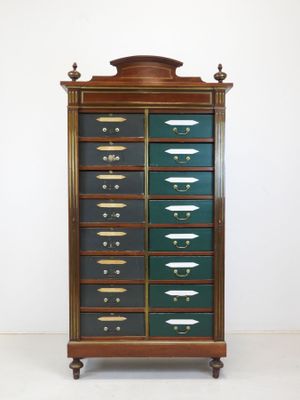 une vieille armoire en bois avec de nombreux tiroirs, surmontée d'autres tiroirs
