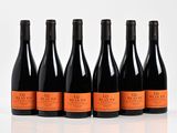 six bouteilles de vin sont alignées sur une surface blanche