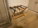un petit porte-bagages en bois dans un coin de la pièce