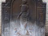 a statue of a woman holding a dog on a stone wall