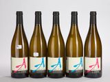 quatre bouteilles de vin sont alignées sur une surface blanche