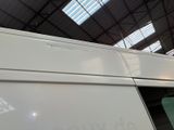 a white van parked inside of a building with a skylight above it