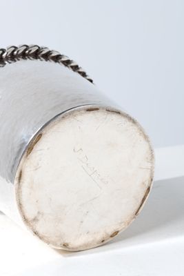 a silver cup that is sitting on a white table
