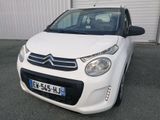 la petite voiture blanche est garée devant un bâtiment