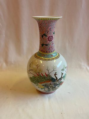 un vase avec un tableau posé sur une table